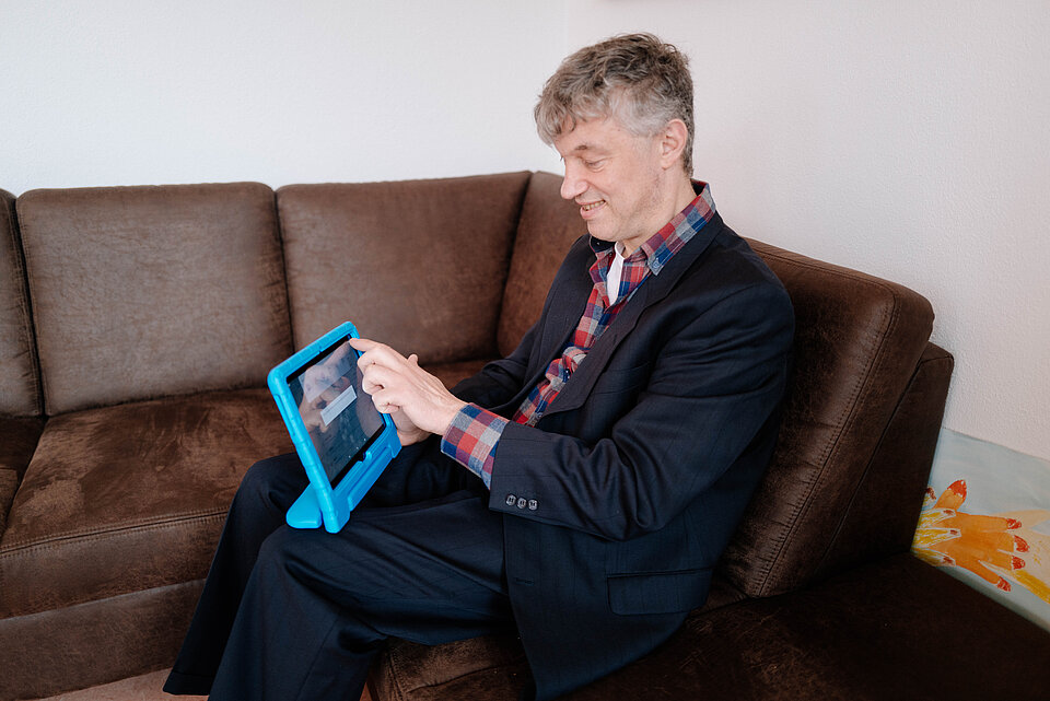 Sitzender Mann benutzt ein Tablet