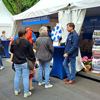 Ein VdK-Infostand mit Menschen am Glücksrad, Quelle: VdK