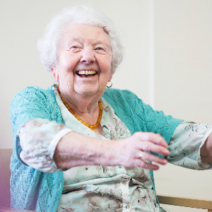 Eine ältere Frau bei sportlichen Übungen in einer Seniorenwohnanlage