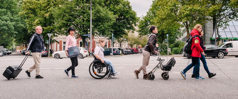 5 Personen mit Behinderungen überqueren eine Straße in Hamburg