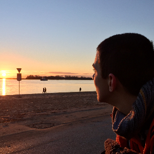 Ein Junge blickt in den Sonnenuntergang