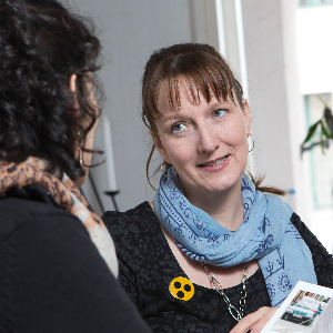 Auf dem Foto zwei Frauen mittleren Alters im Gespräch. Eine von ihnen trägt einen gelben Button mit drei schwarzen Punkten am Ausschnitt des Oberteils. Sie schaut die andere, schräg von hinten abgebildete Frau an. Bild: DBSV/Friese